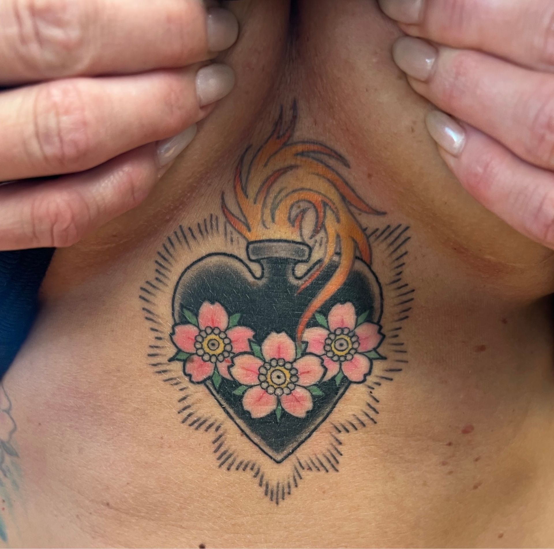 A man has a tattoo of praying hands and a cross on his chest