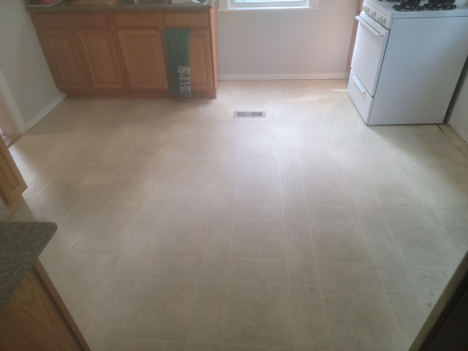 Kitchen with light beige tile floor, wooden cabinets, and a white stove.