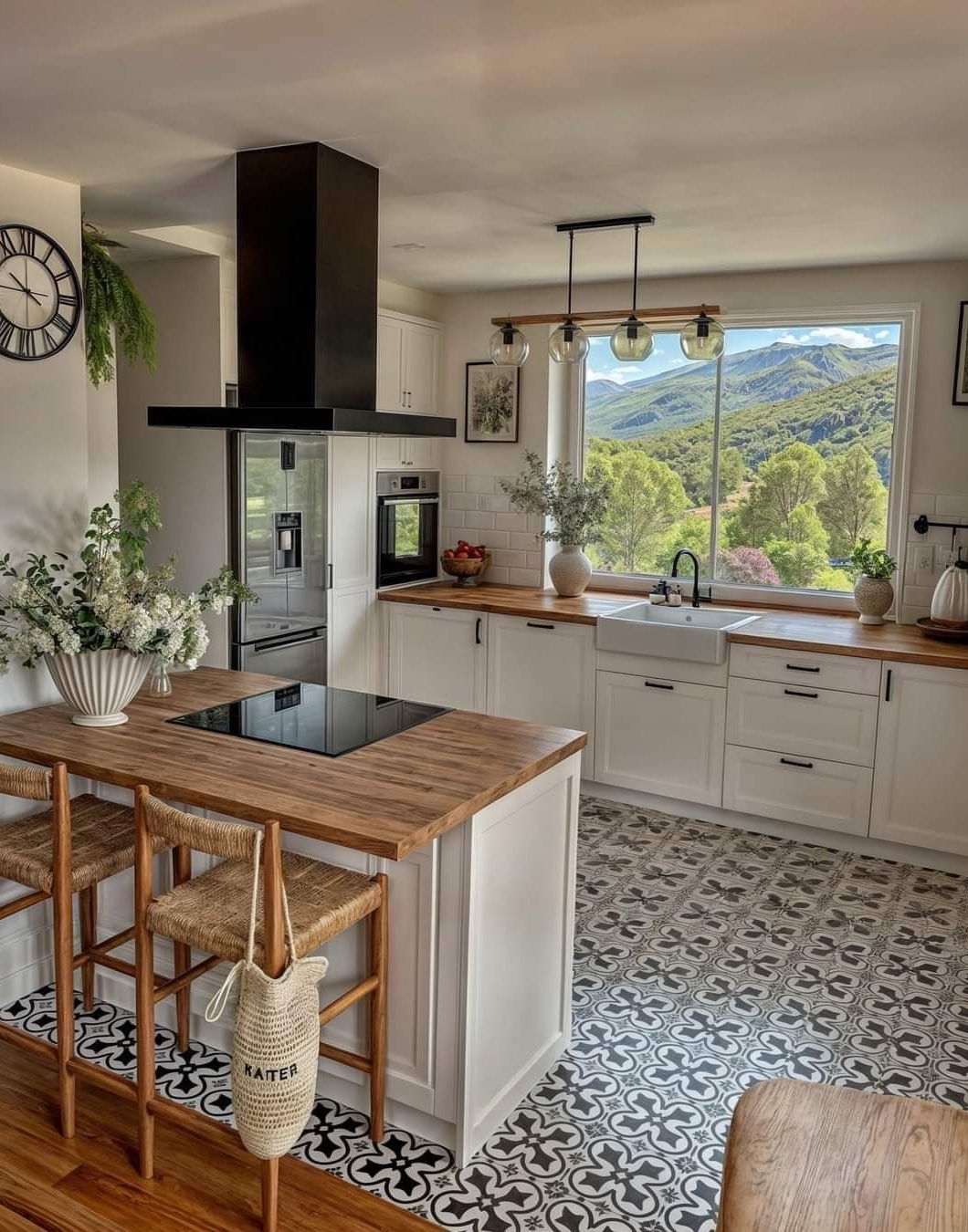 Cozy kitchen with white cabinets, wood island, and scenic mountain view. Black and white tile floor.