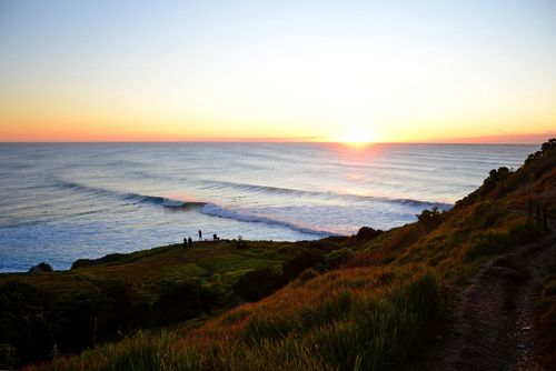 A Sunset Over a Body of Water With a Cliff in the Foreground — Cape Byron Plumbing in Lennox Head, NSW