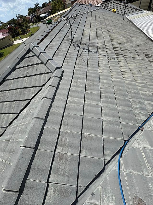 A Roof with a Lot of Tiles and a Blue Hose on It — Boss Roof Tiling and Restoration in Sunshine Coast, QLD