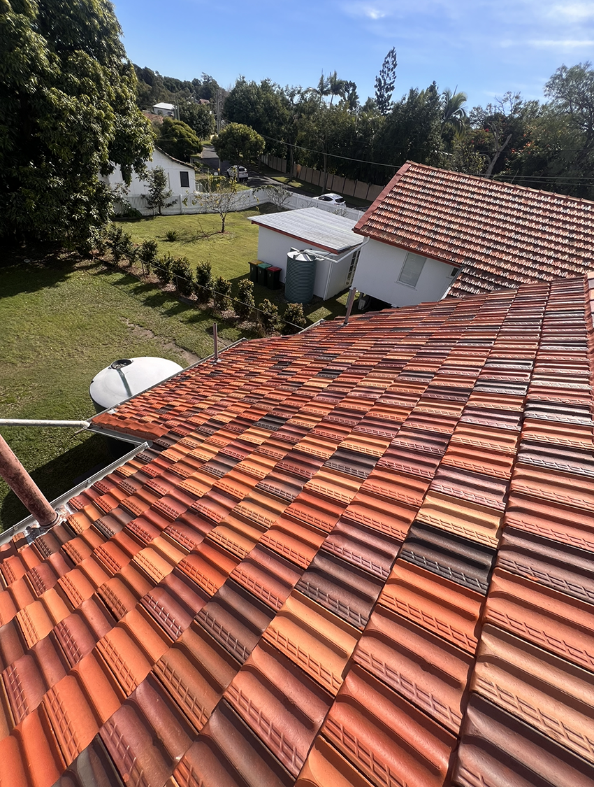 A Roof with a Lot of Tiles on It and a House in the Background — Boss Roof Tiling and Restoration in Caboolture, QLD