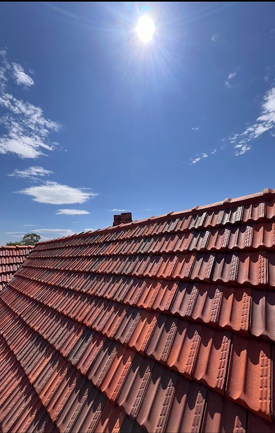A Roof with Red Tiles and a Blue Sky in the Background — Boss Roof Tiling and Restoration in Caboolture, QLD