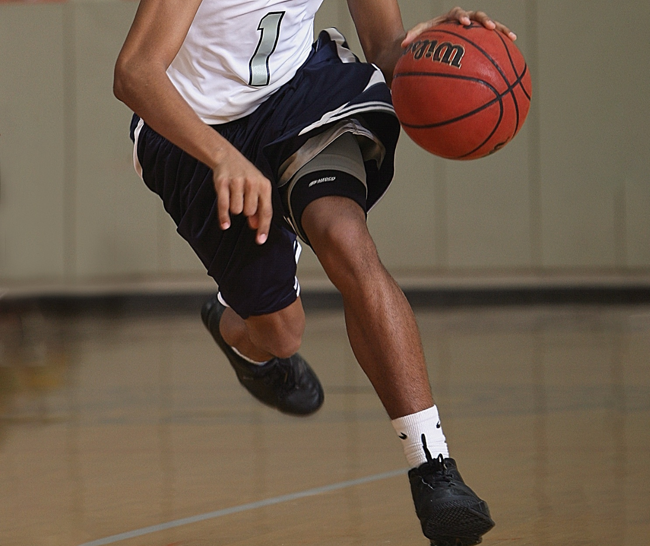 A basketball player is jumping in the air while holding a basketball.