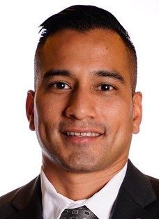 A man in a suit and tie is smiling for the camera.