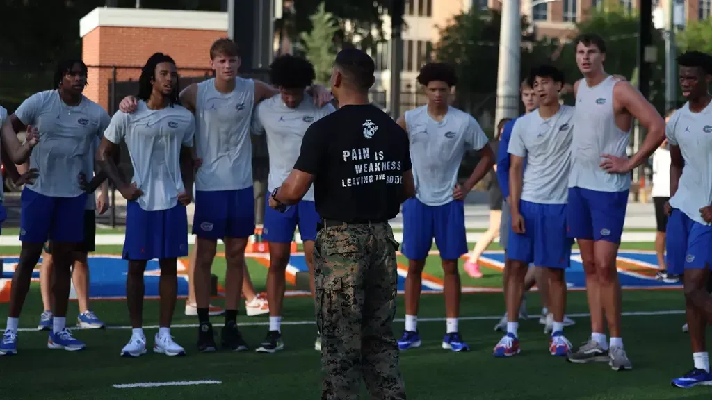 A group of young men are standing in a circle on a field.
