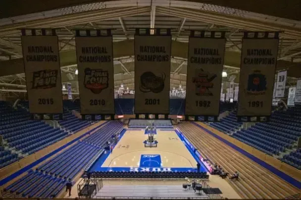 Basketball arena with blue seats, court, and championship banners from 1991, 1992, 2001, 2010, and 2015.