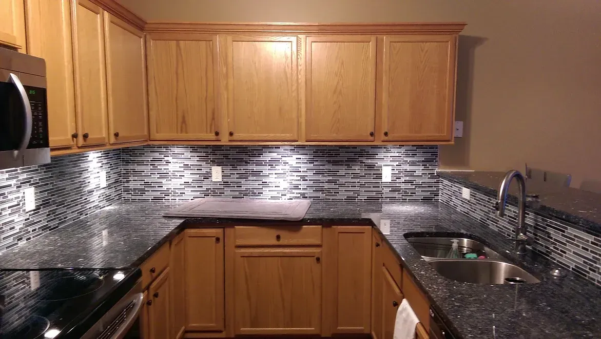 A kitchen with wooden cabinets and granite counter tops