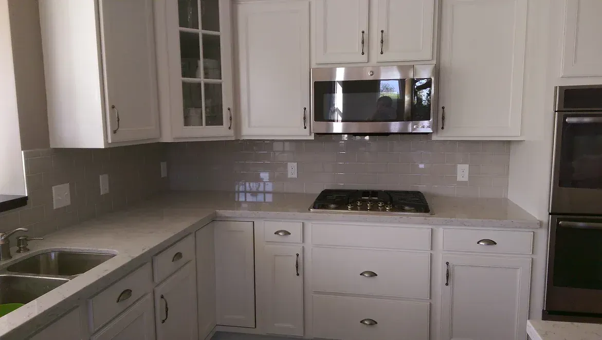 A kitchen with white cabinets and stainless steel appliances.