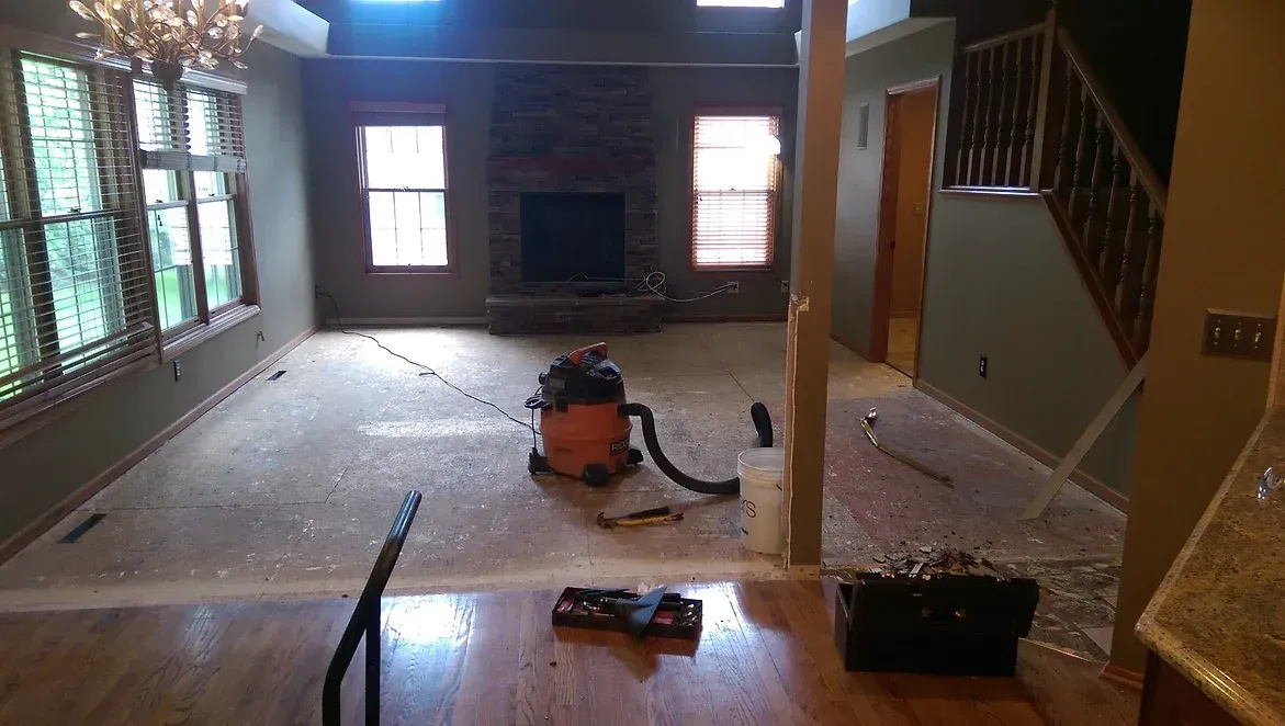 A living room with hardwood floors and a vacuum cleaner on the floor.