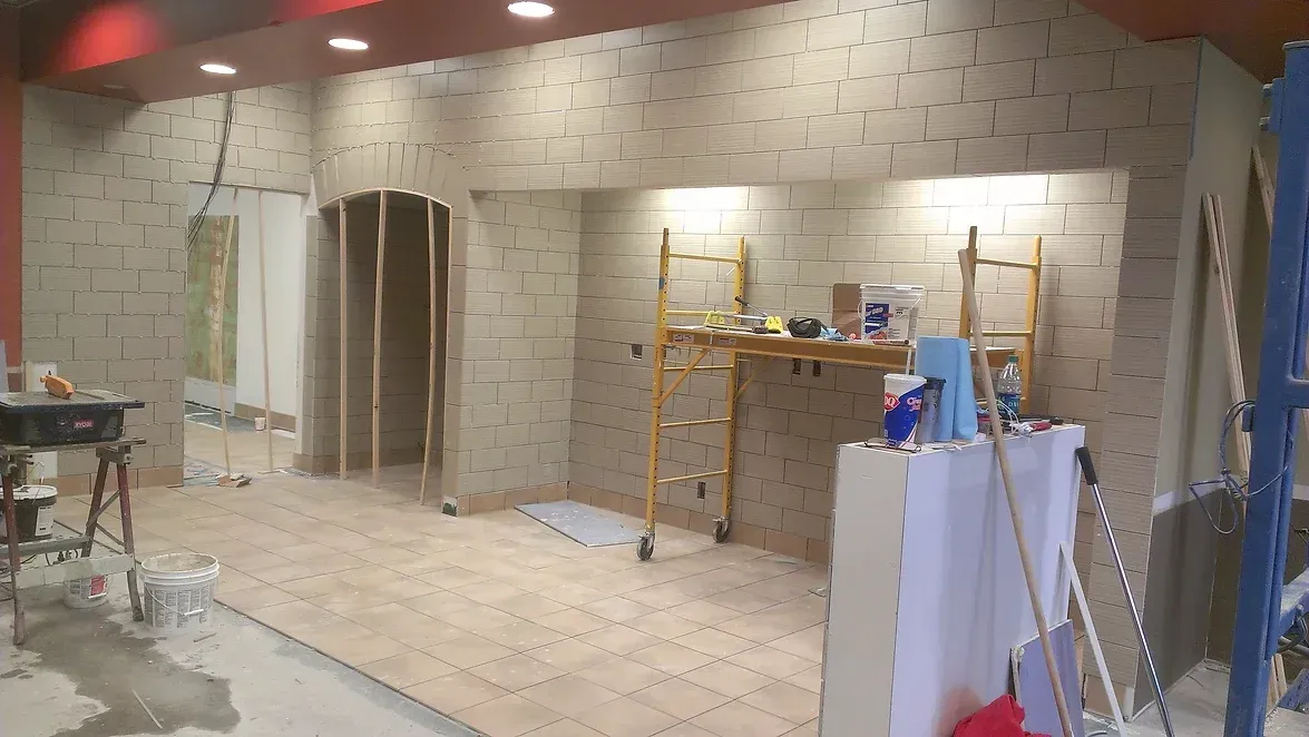 A room that is being remodeled with brick walls and a scaffolding.