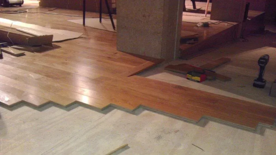 A wooden floor is being installed in a room.