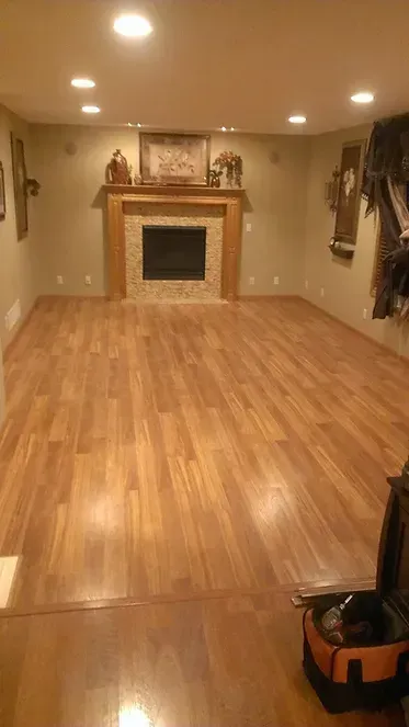 A large empty room with hardwood floors and a fireplace.