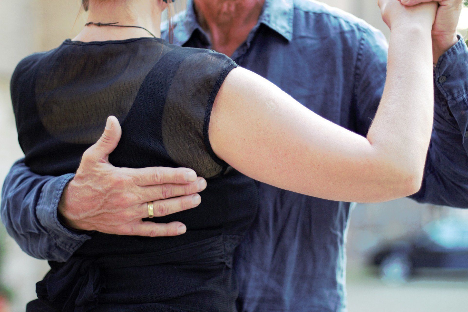 Männerhand auf Rücken einer Tango-Tänzerin