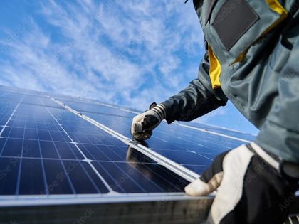 A man is installing solar panels on a roof.