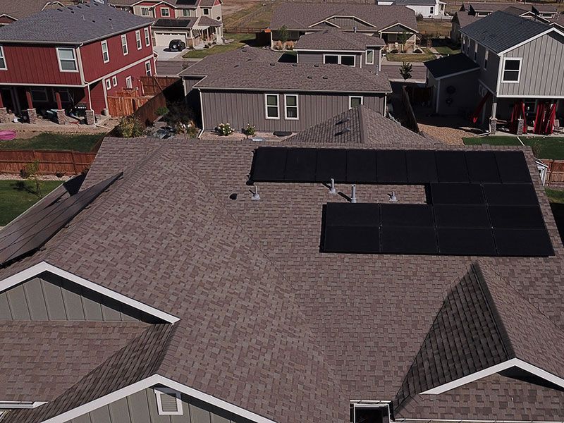 An aerial view of a house with solar panels on the roof.