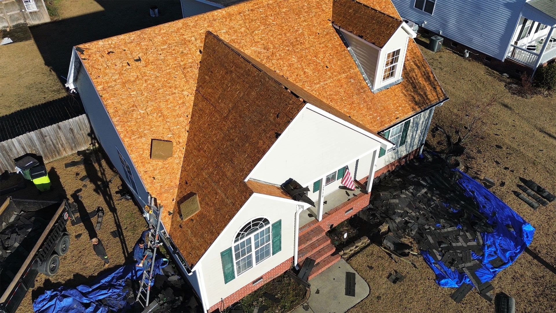 An aerial view of a house with a roof that is being repaired.