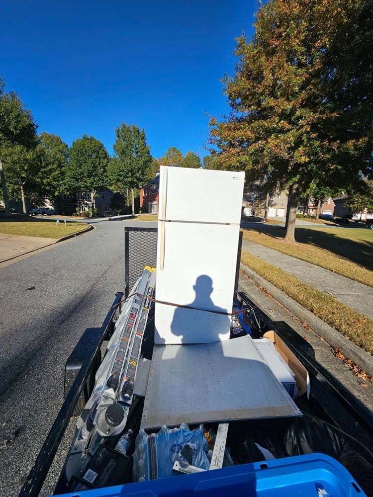A white refrigerator is sitting on top of a trailer.