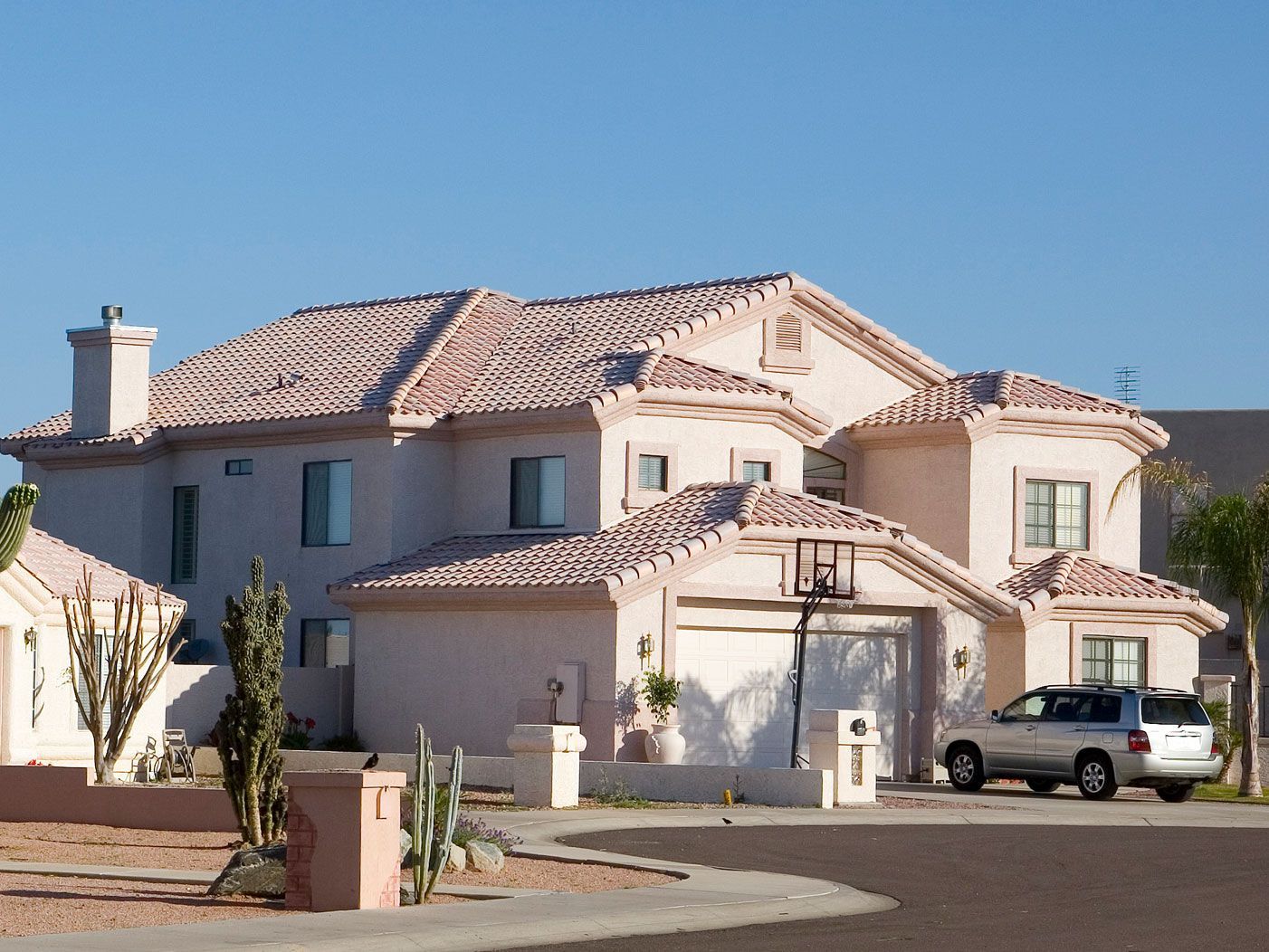 A large white house with a car parked in front of it
