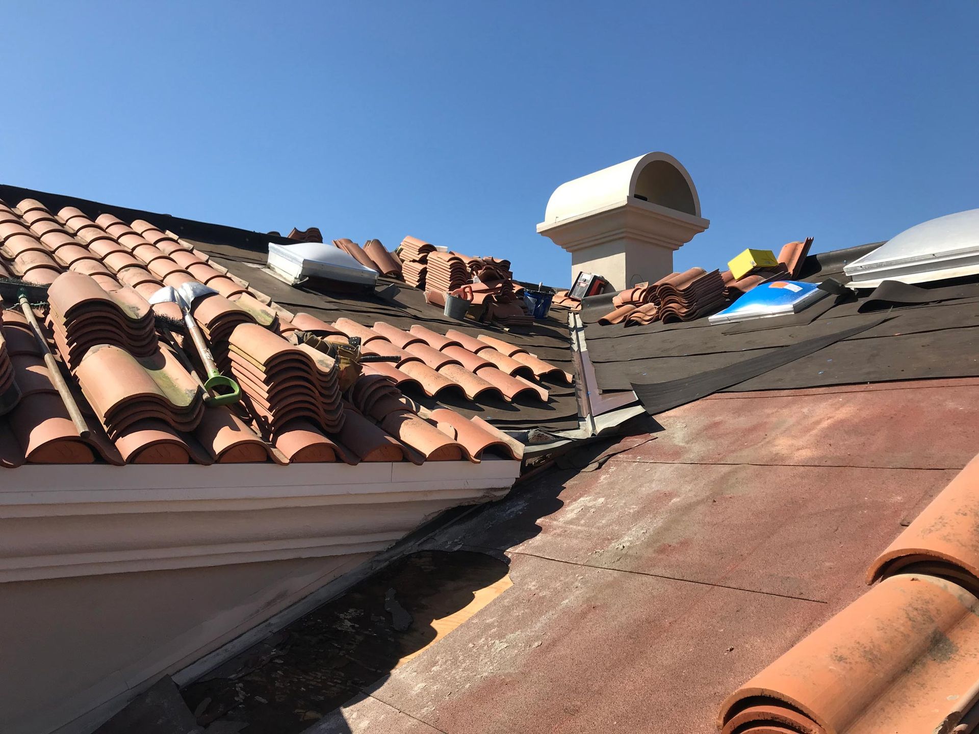A roof with a lot of tiles on it and a chimney on top of it.