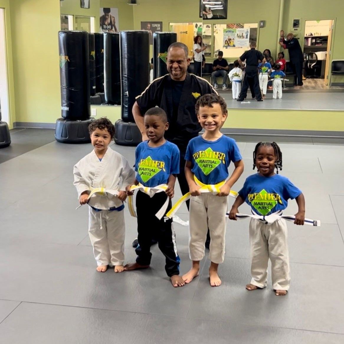 A group of young girls are practicing karate in a gym.