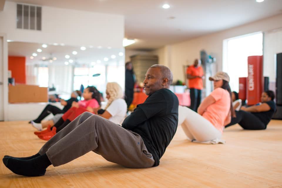 A group of people are doing sit ups in a gym.