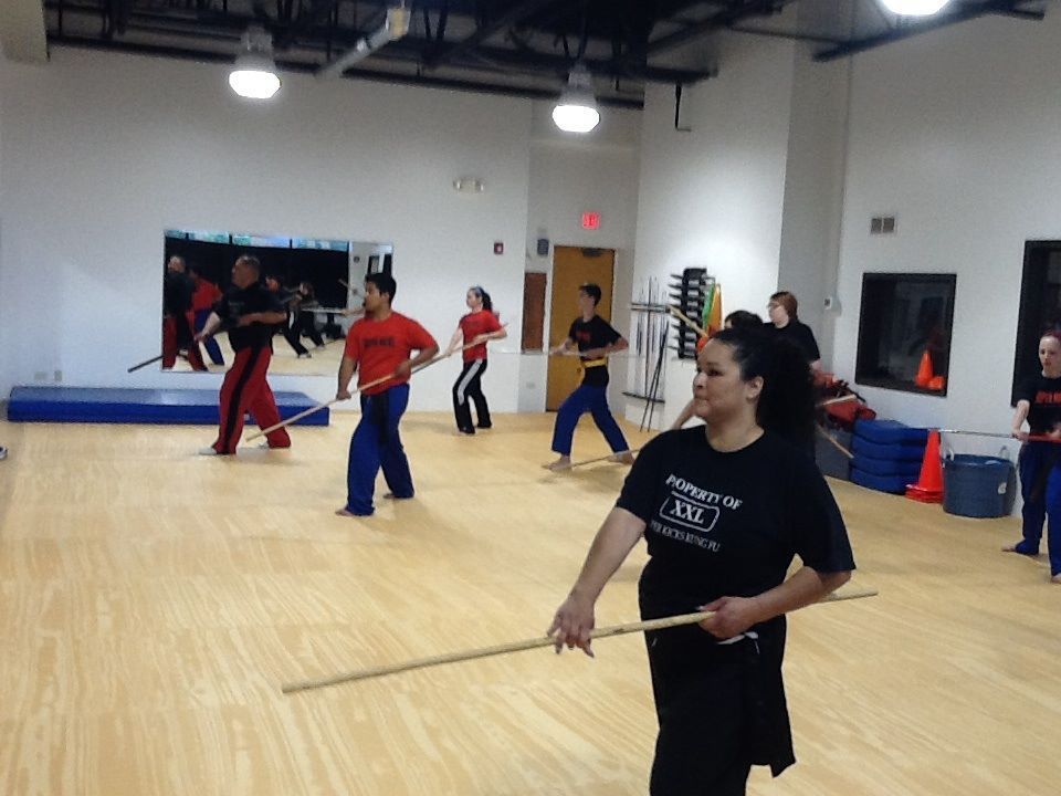 A group of people are practicing martial arts in a gym