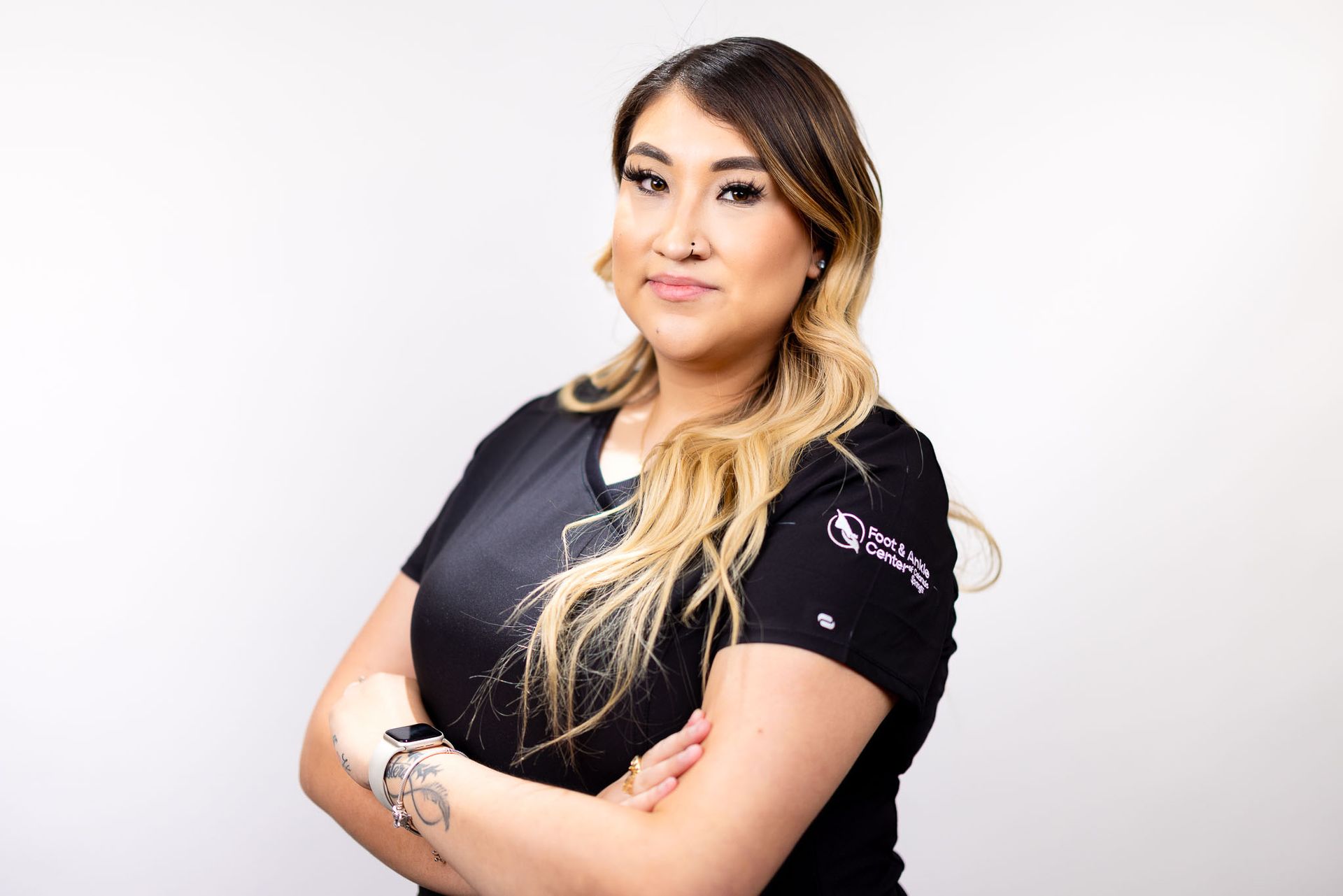 Maritza a medical assistant in a black shirt is standing with her arms crossed.