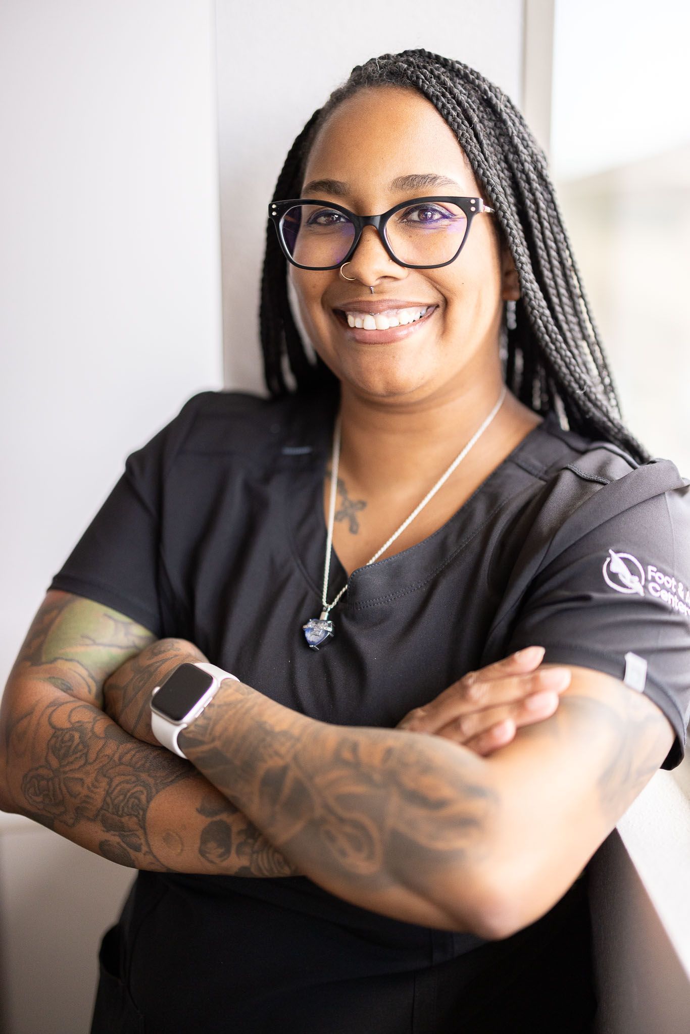 Krystal the Clinical Administrator is standing with her arms crossed and smiling.