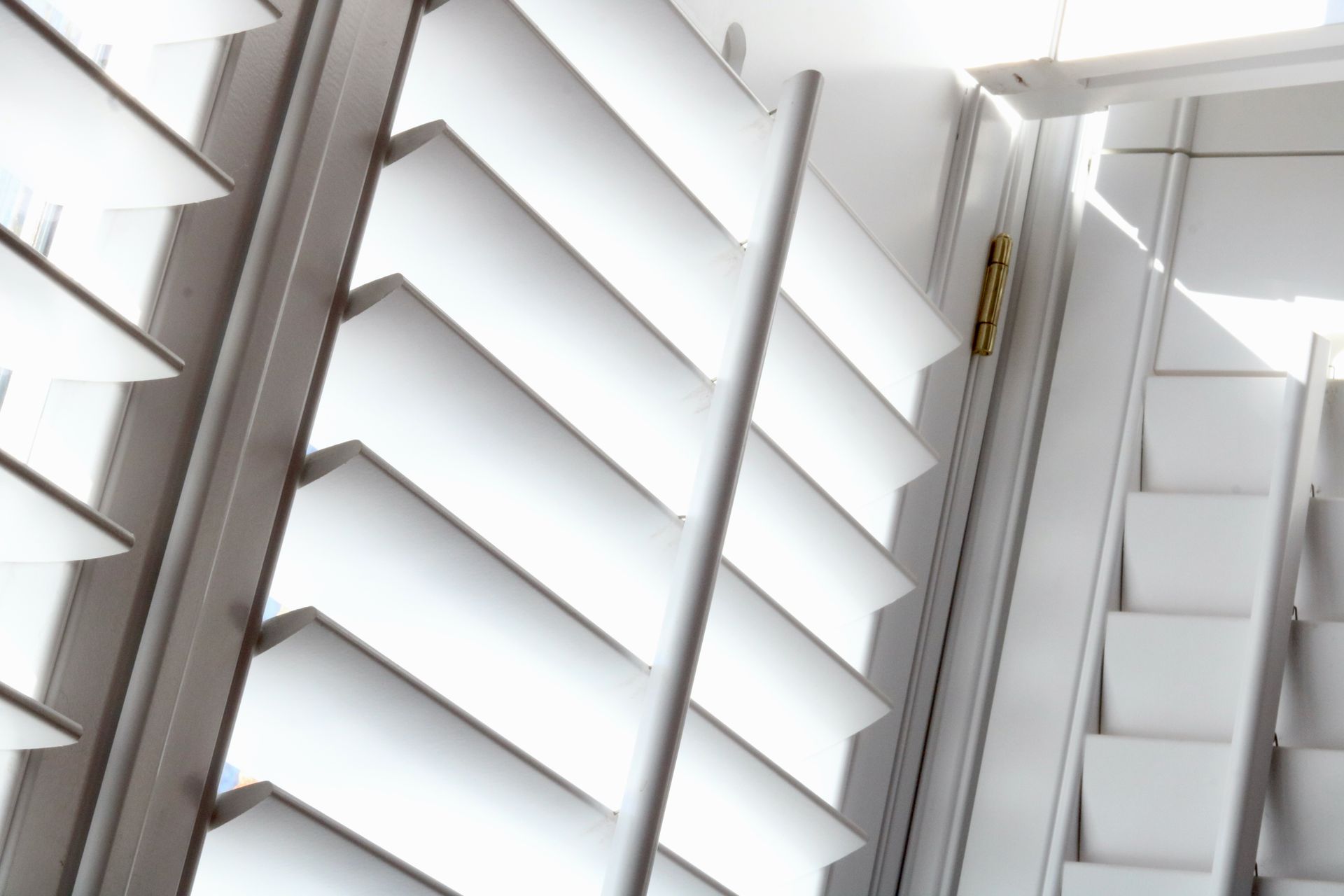 Angled full-frame image of light shining through plantation shutters. Angled full-frame image of light shining through plantation shutters.