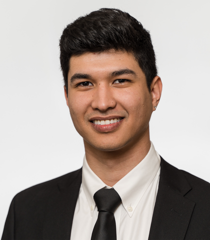 A man in a suit and tie is smiling for the camera