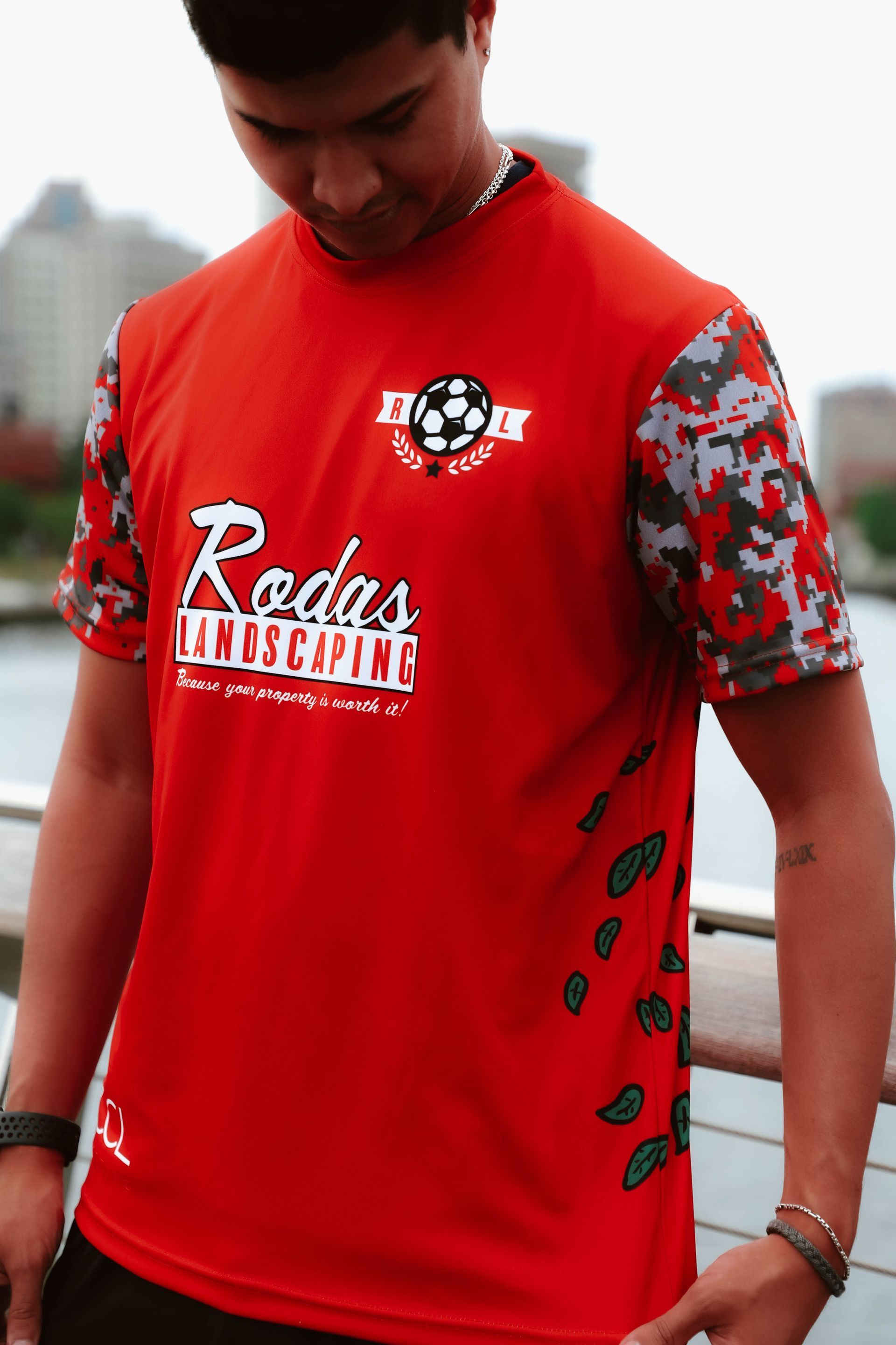 A man wearing a red t-shirt that says rodas landscaping