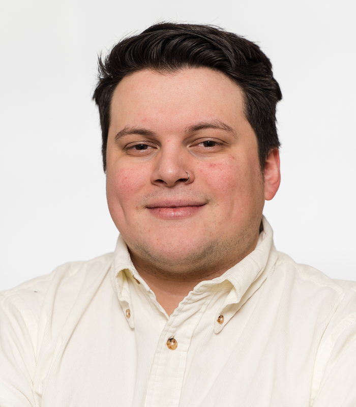 A man in a white shirt is smiling for the camera