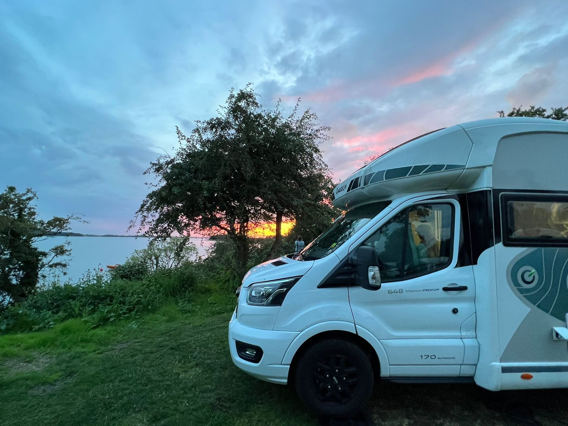 Camper geparkeerd bij zonsondergang in een landelijke omgeving in Zweden