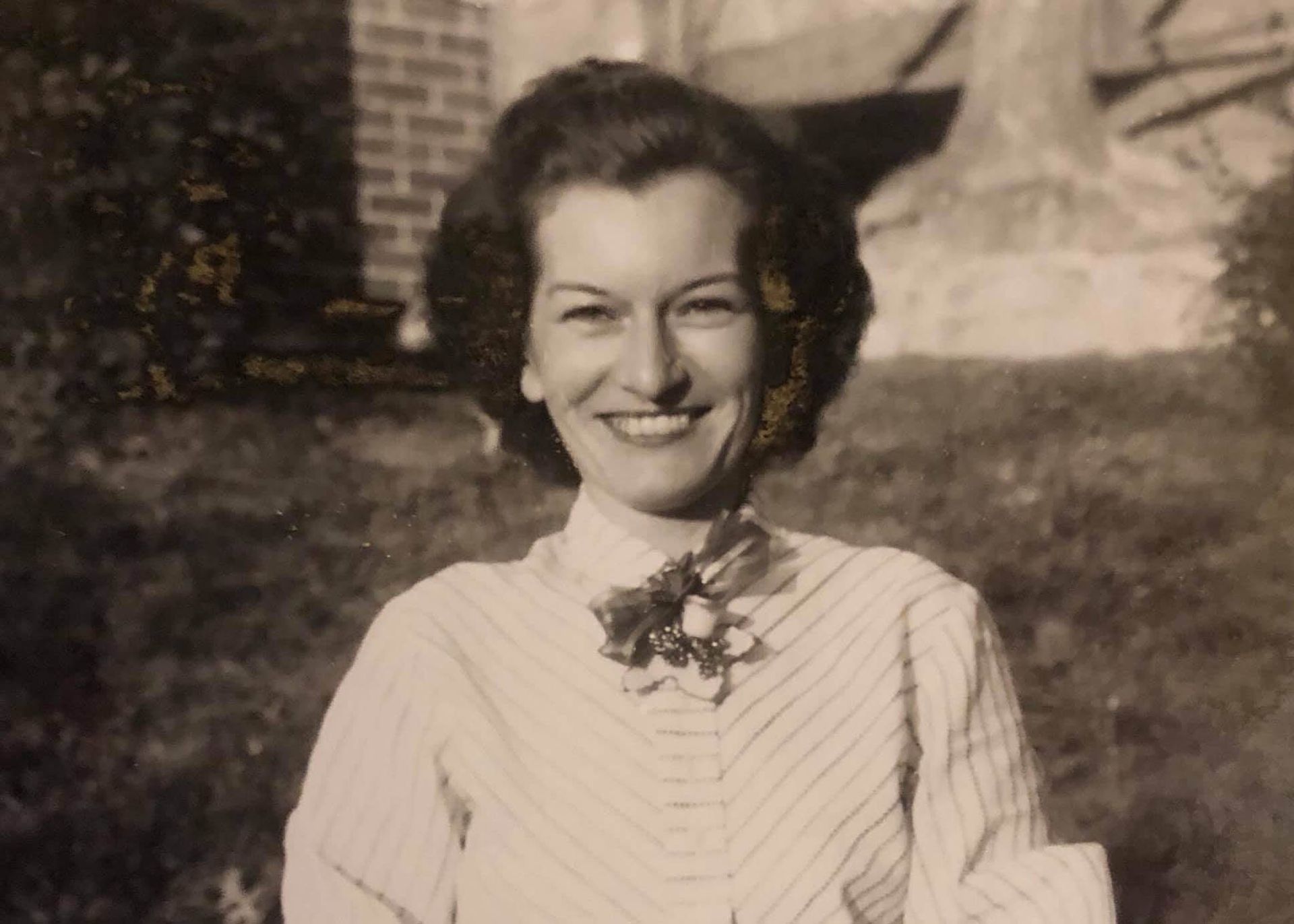 A woman is smiling in a black and white photo.