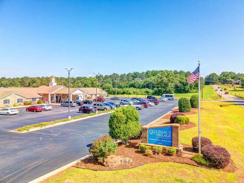 An aerial view of a parking lot with a sign and an american flag.