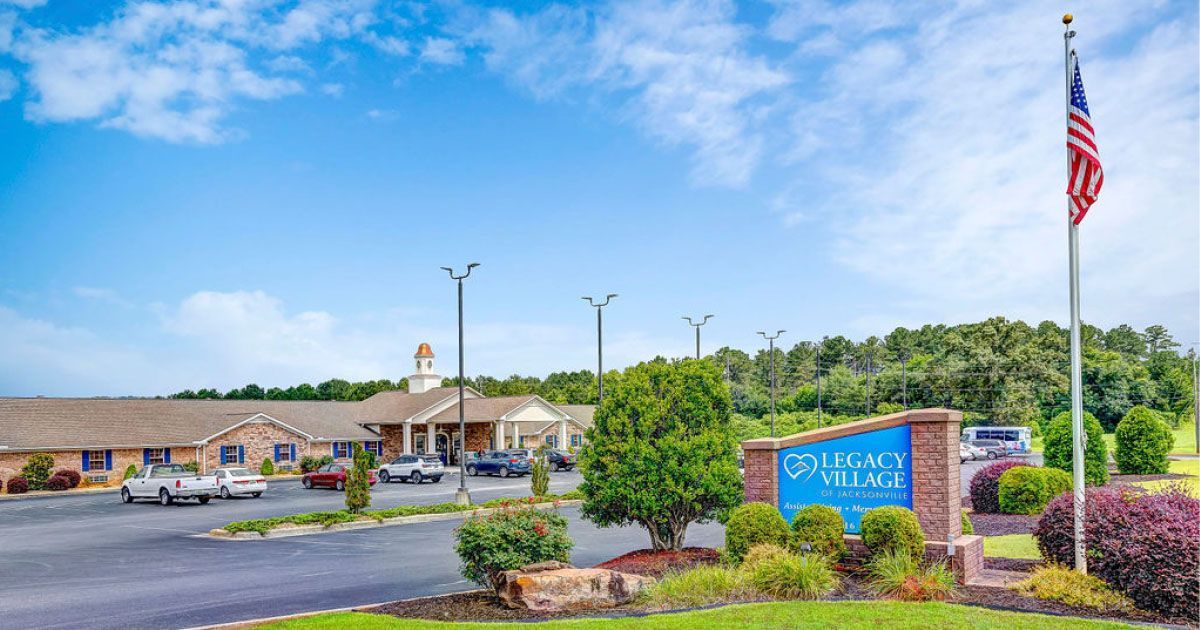 A large building with a sign in front of it and a flag on a pole.