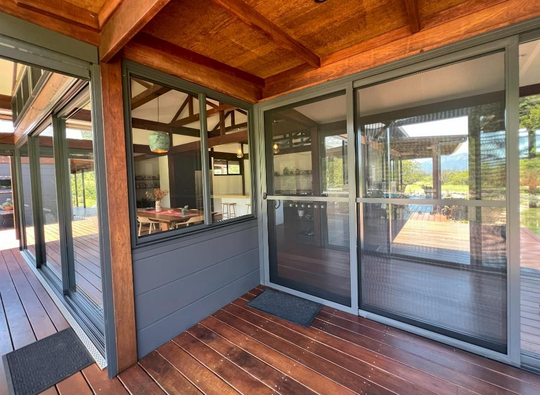A Screened In Porch With Sliding Glass Doors And A Wooden Deck — Datco Group In South Murwillumbah, NSW