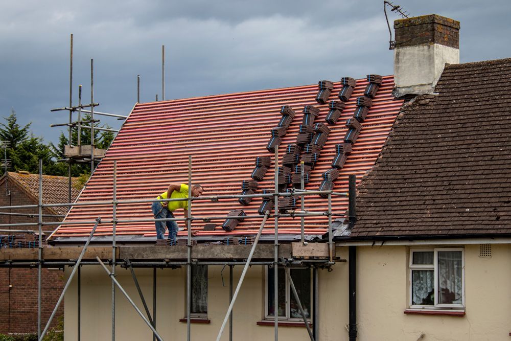 Professional Worker Preparing New Shingles for Roof Replacement