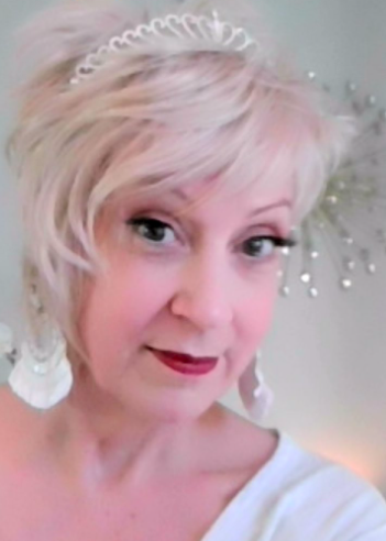 A woman wearing a tiara and earrings is taking a selfie.