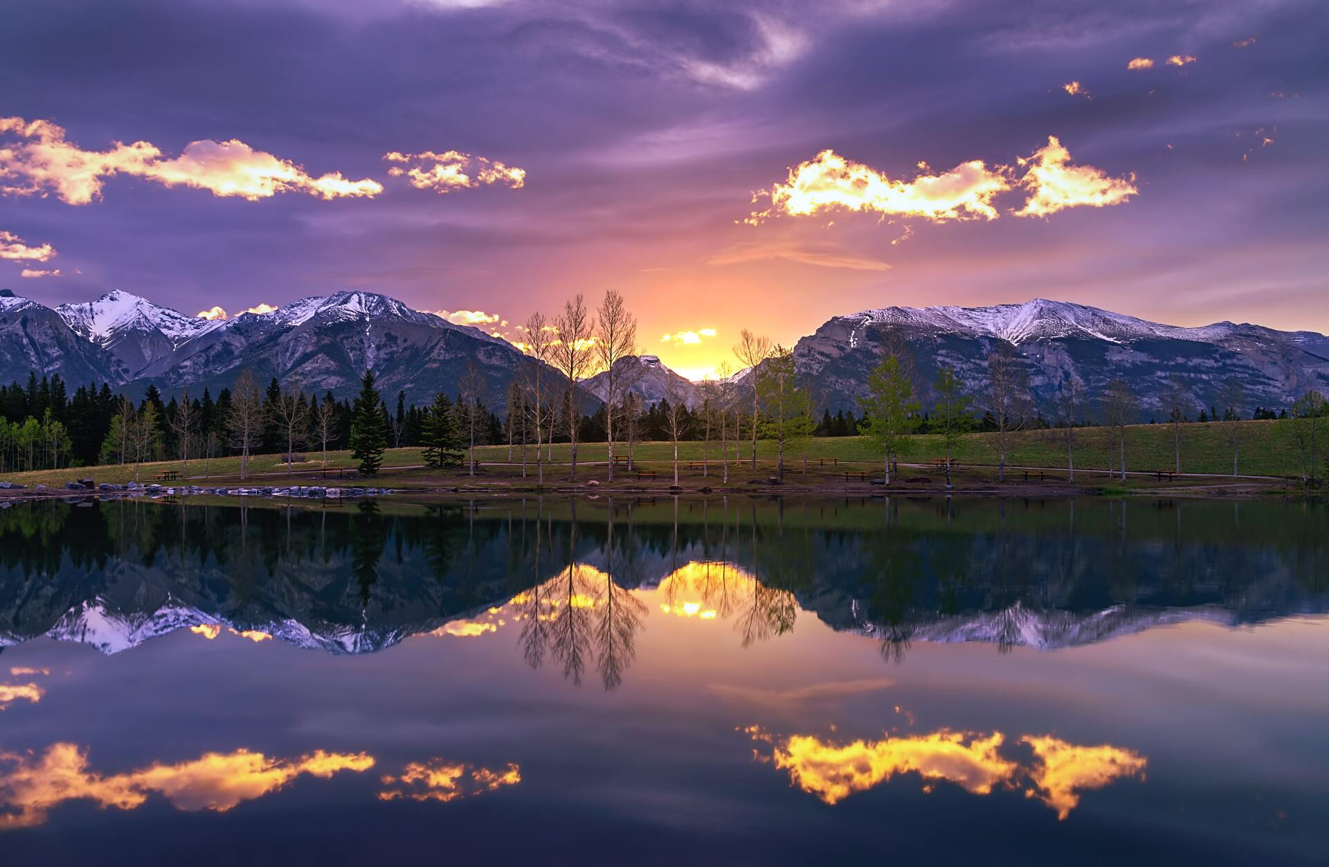 A sunset over a lake with mountains in the background