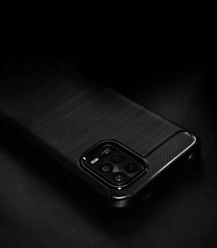 Black phone case with textured back and camera bump, on a dark surface.
