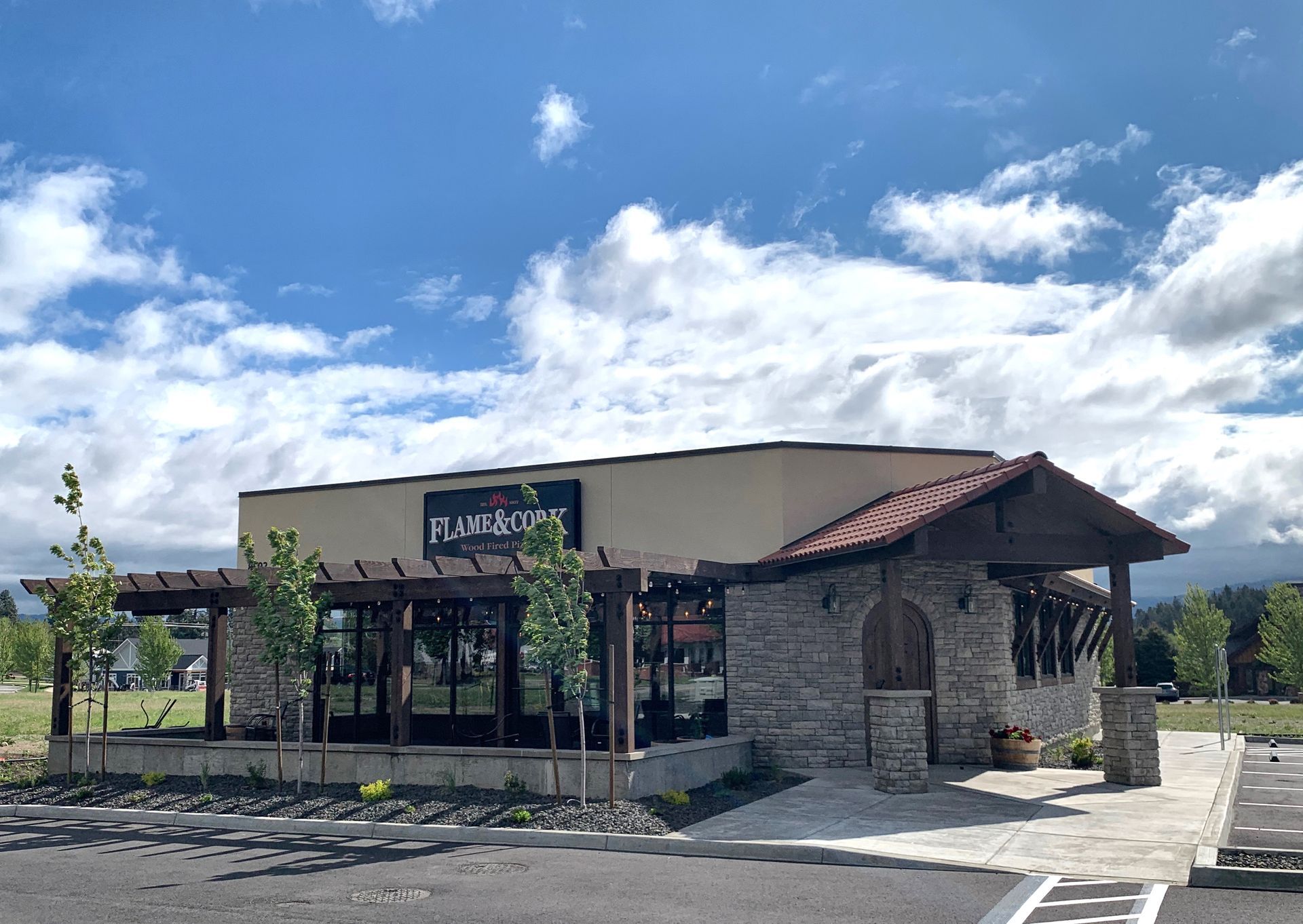 A large building with a lot of windows is sitting in a parking lot.