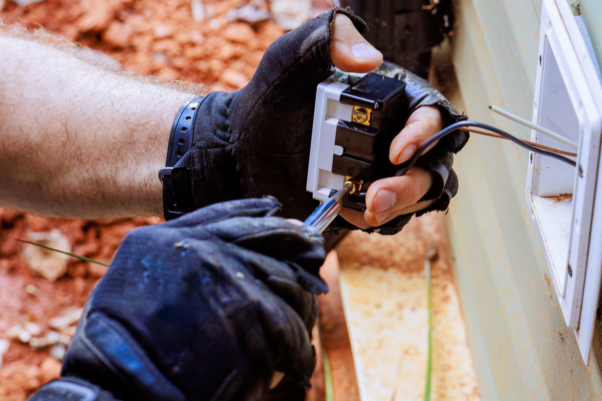 A person is installing a light switch on a wall.