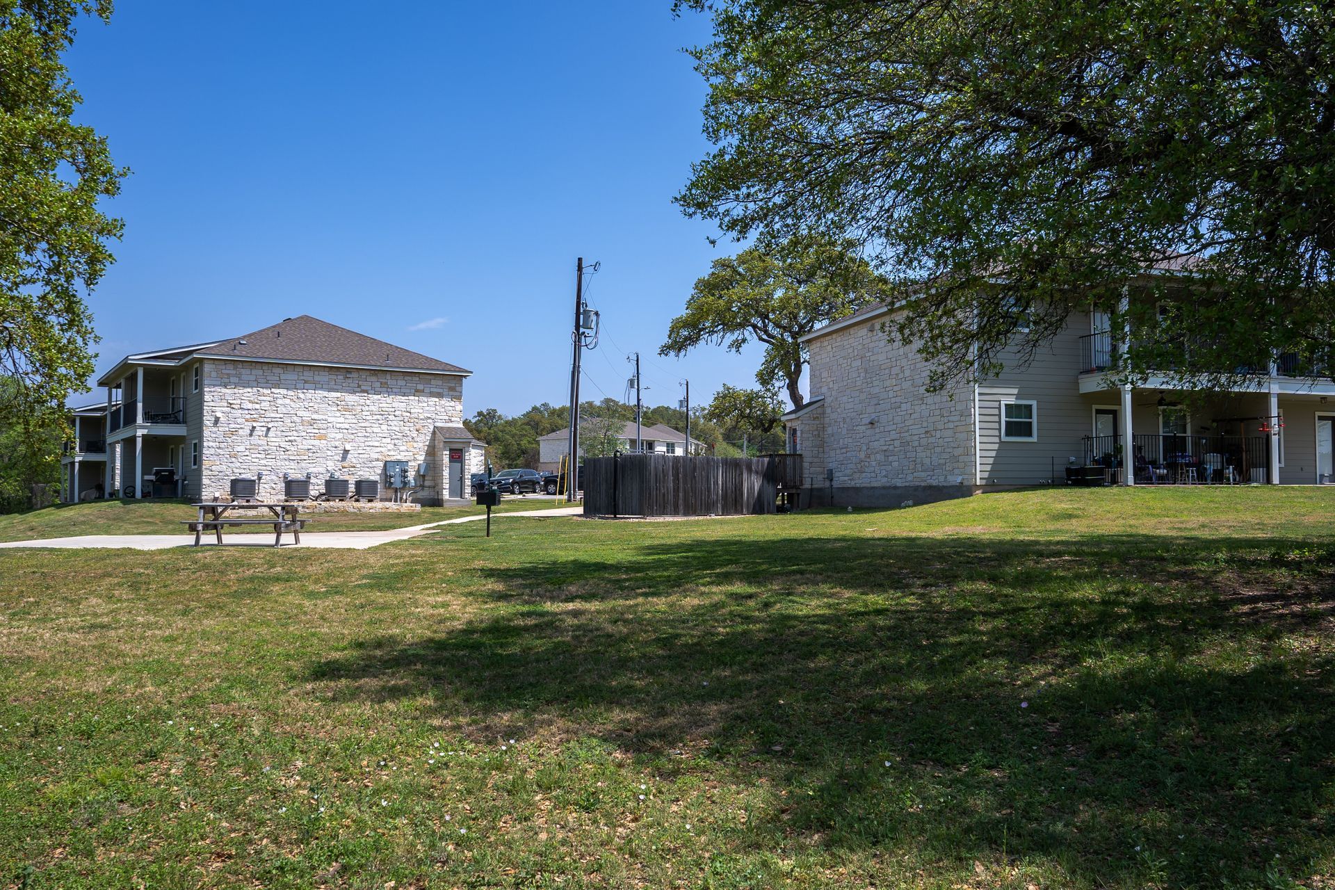 There are two buildings in the background and a picnic table in the foreground.