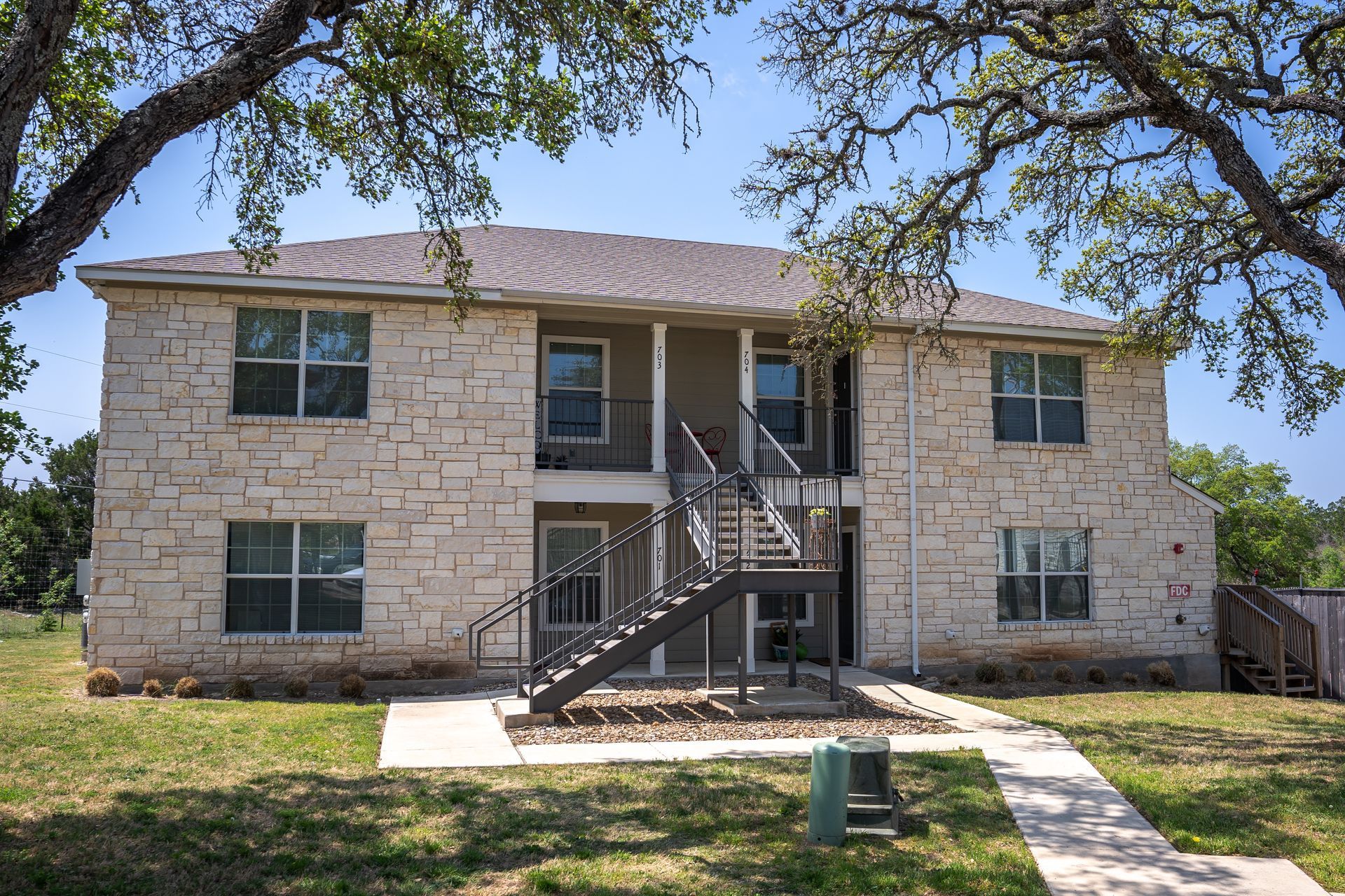 A large brick apartment building with stairs leading up to the second floor.