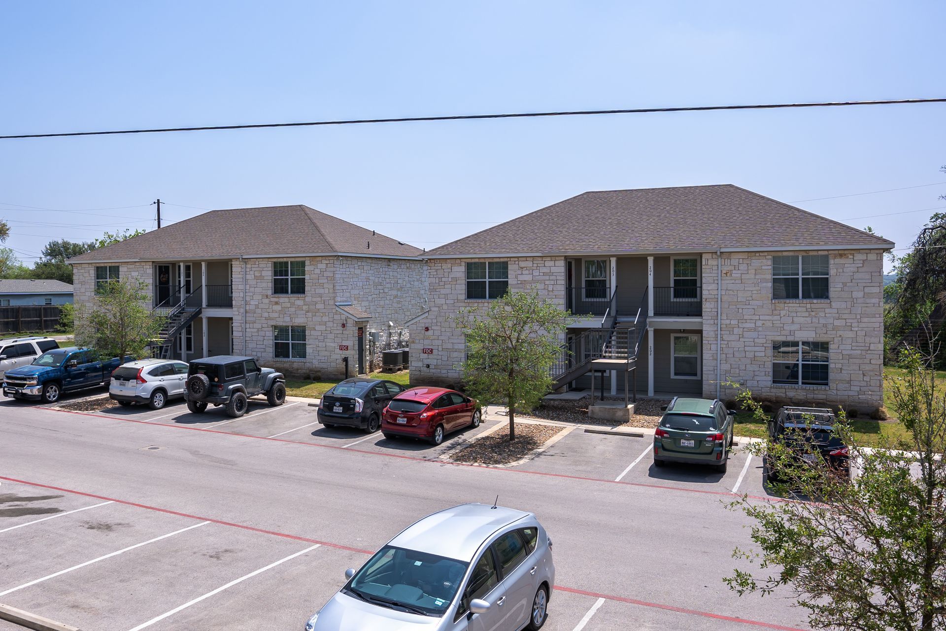 A parking lot in front of a building with cars parked in front of it.
