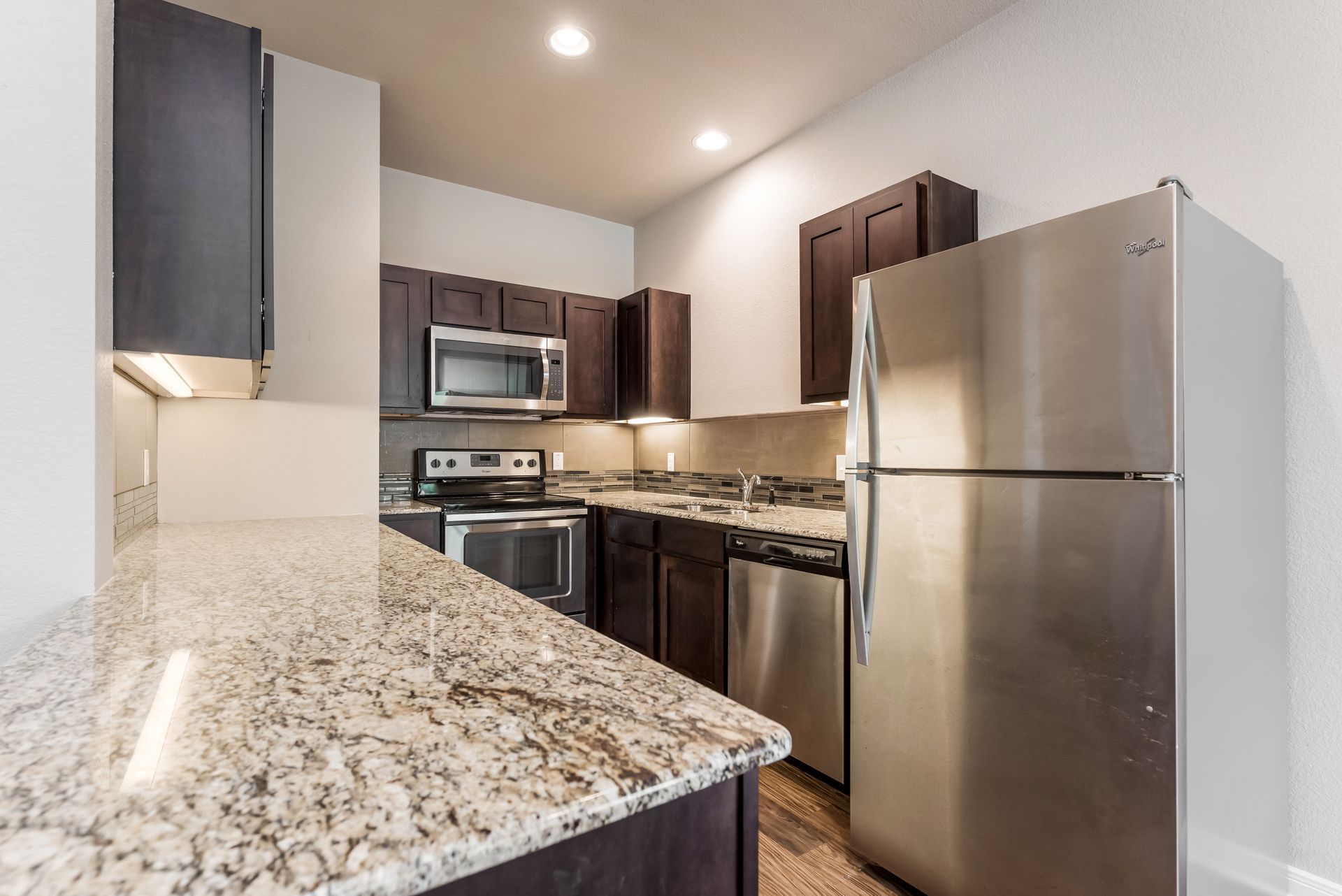 A kitchen with stainless steel appliances and granite counter tops