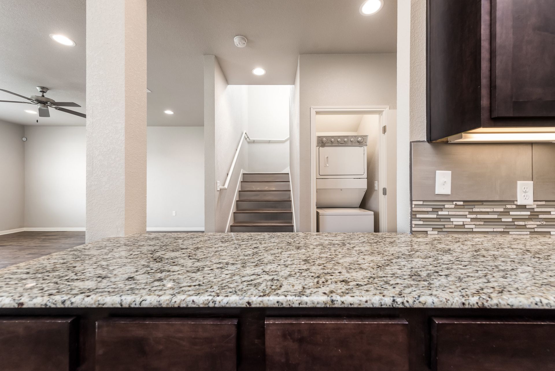 A kitchen with granite counter tops and brown cabinets