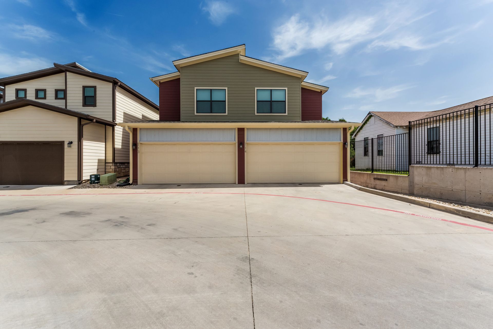 A house with two garages and a fence in front of it